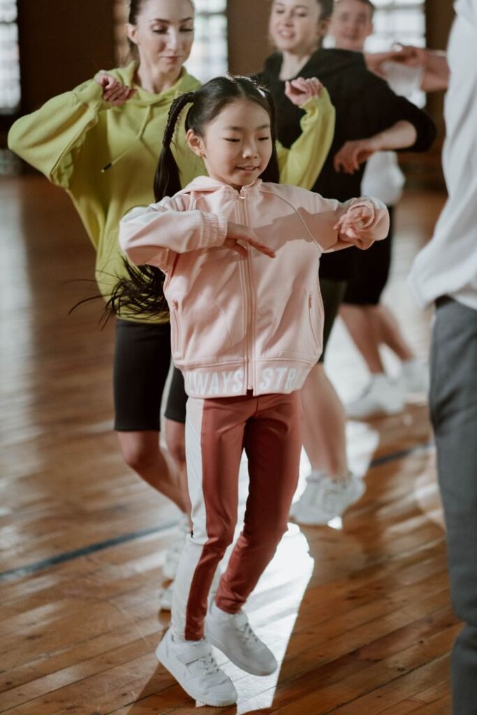 Children and adults enjoying an energetic dance class indoors, promoting fitness and fun.